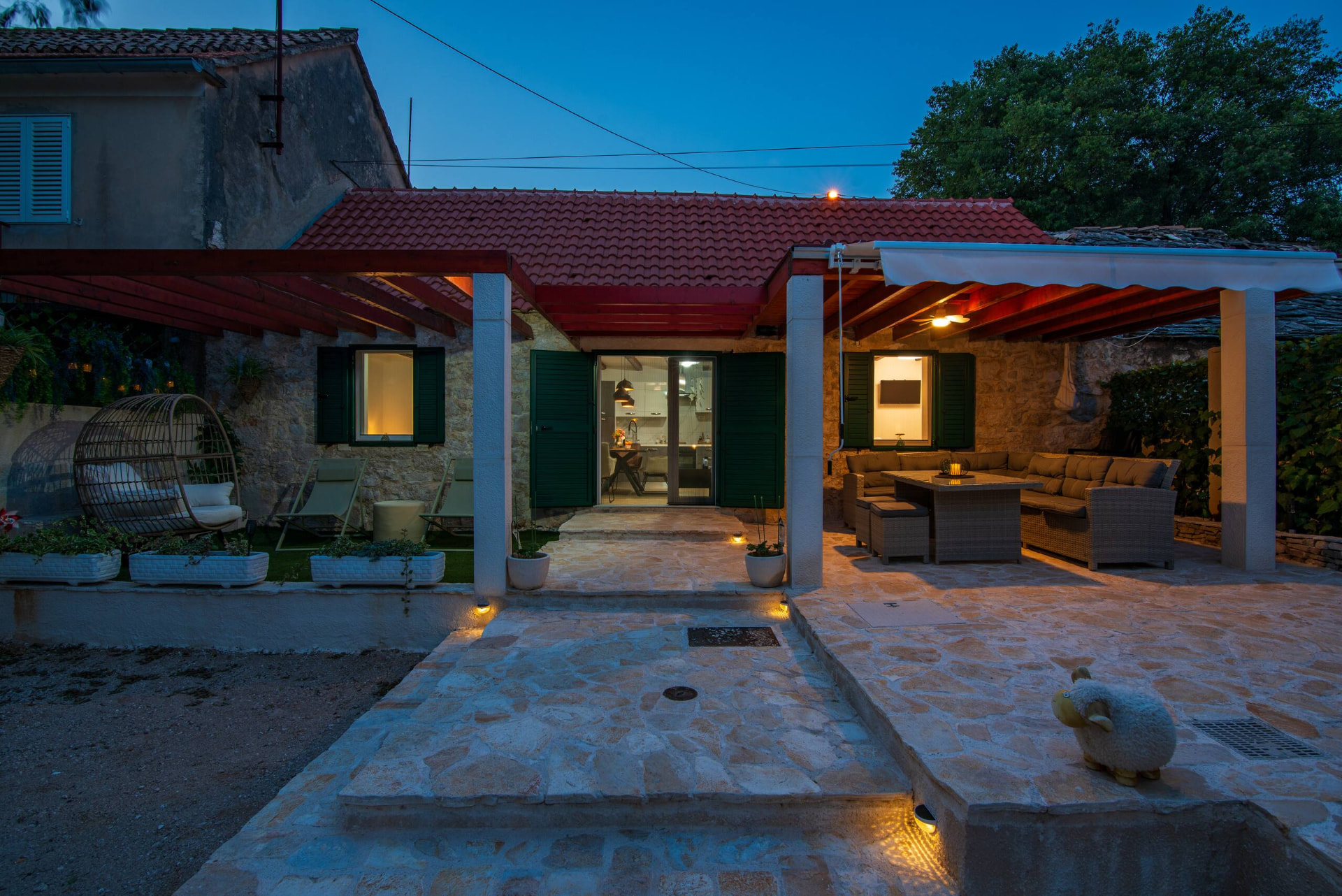Terrace — stone courtyard and covered lounge at dusk — Kameni Dvori