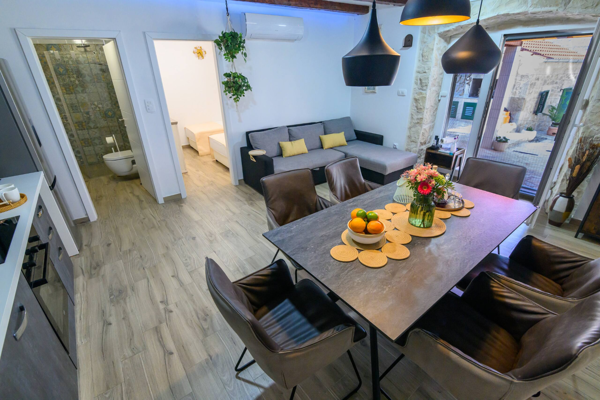 Open plan living and dining room with exposed stone walls